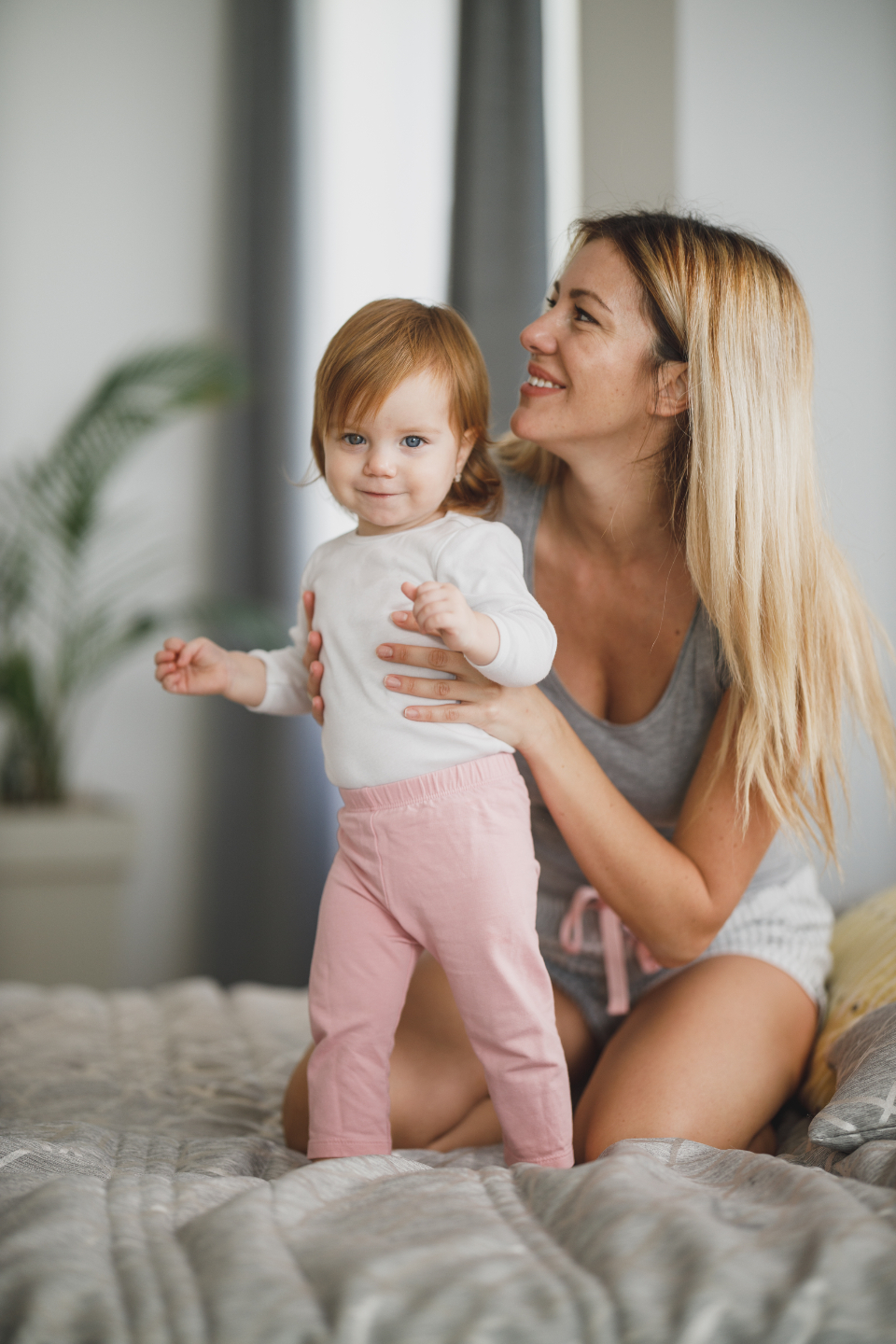 A mother and baby resting together in a bright, calm bedroom